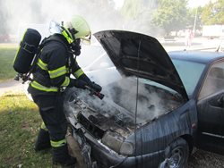 Požár osobního automobilu na parkovišti v blízkosti nákupního střediska.